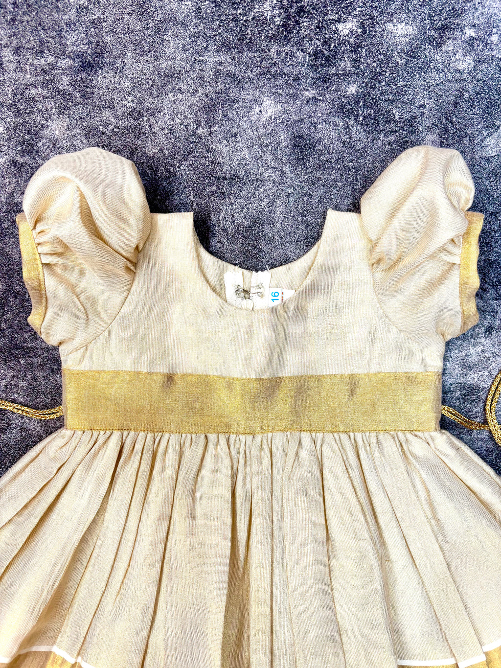 Cream Kasavu golden zari border frock, knee-length Onam dress for baby girl
